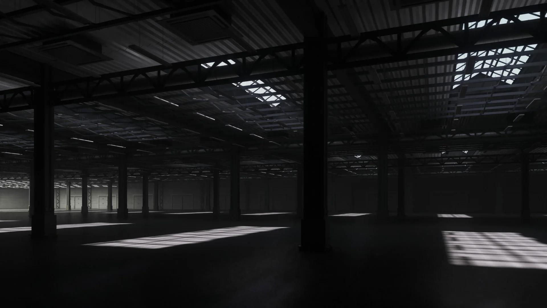 Interior of a large industrial warehouse with steel columns and daylight through roof glazing
